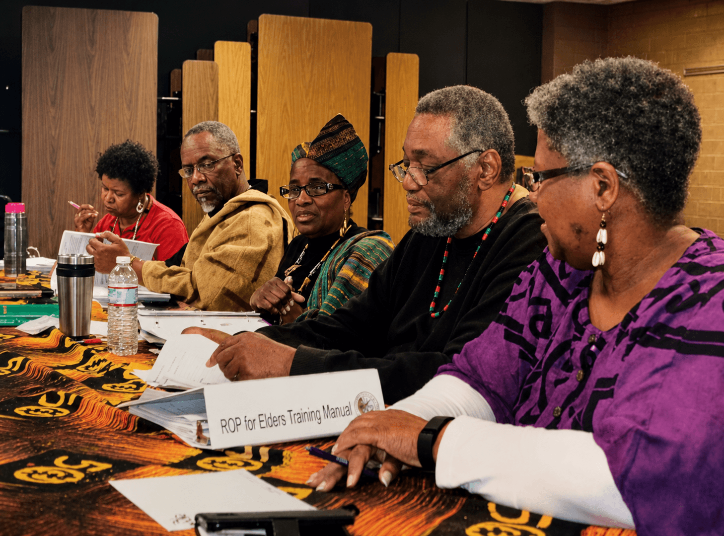 AROPI facilitators and trainers reviewing the Rites of Passage training manual